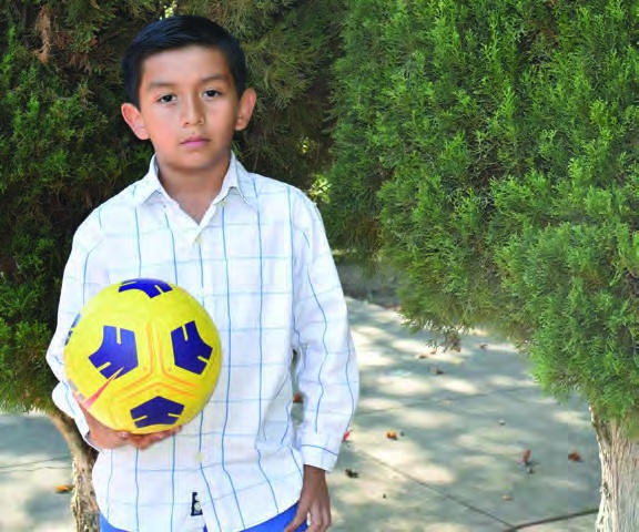 Angel holding a soccer ball in the 2022 annual report.