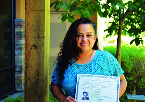 Angelica holding her citizenship certificate in the 2021 annual report.